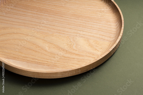 Wooden flat plates on a green background. The concept of ecological tableware. Products for modern kitchen. Zero emissions. photo