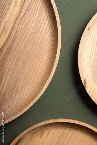 Wooden flat plates on a green background. The concept of ecological tableware. Products for modern kitchen. Zero emissions. photo