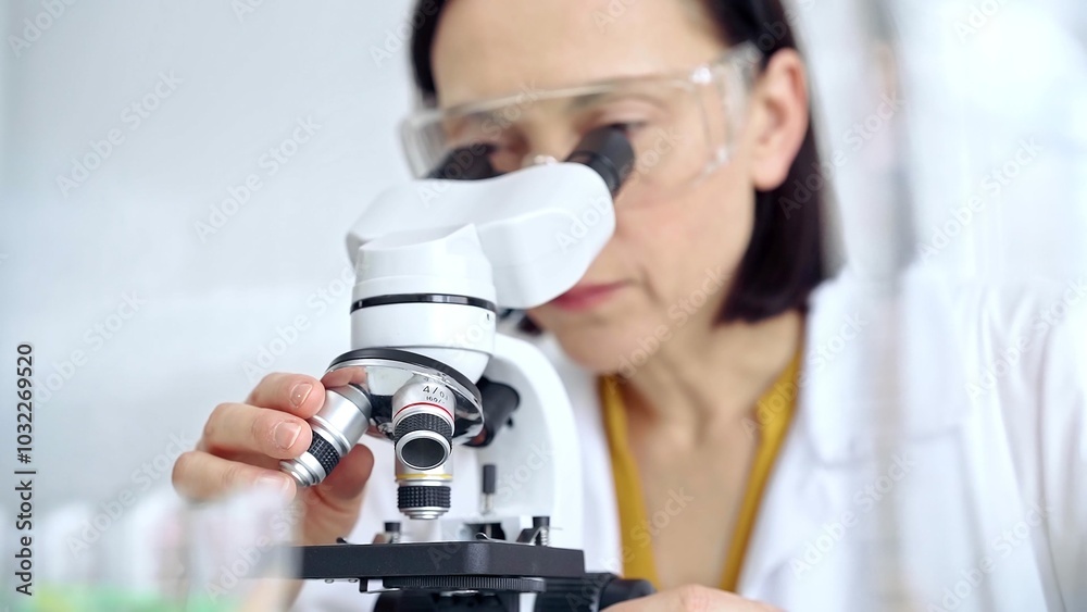 Woman scientist using microscope in laboratory. Microbiology science concept Woman scientist using microscope in laboratory. Microbiology science concept