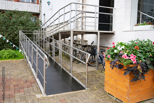 Modern building entrance with wheelchair ramp and stairs.