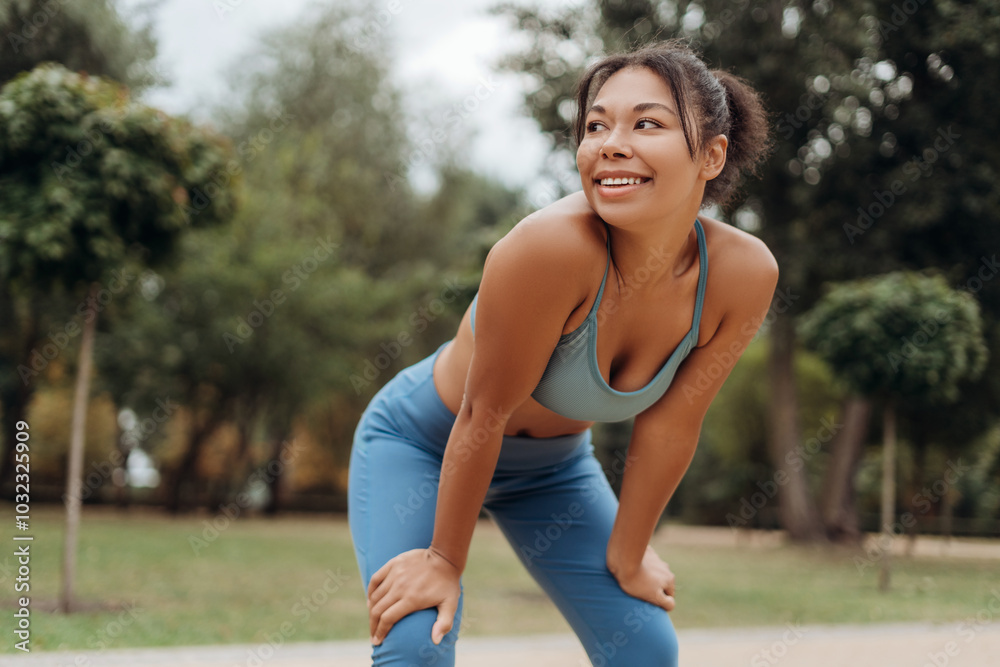 Smiling, beautiful African American woman wearing sport top warming up, stretching, looking away Smiling, beautiful African American woman wearing sport top warming up, stretching, looking away