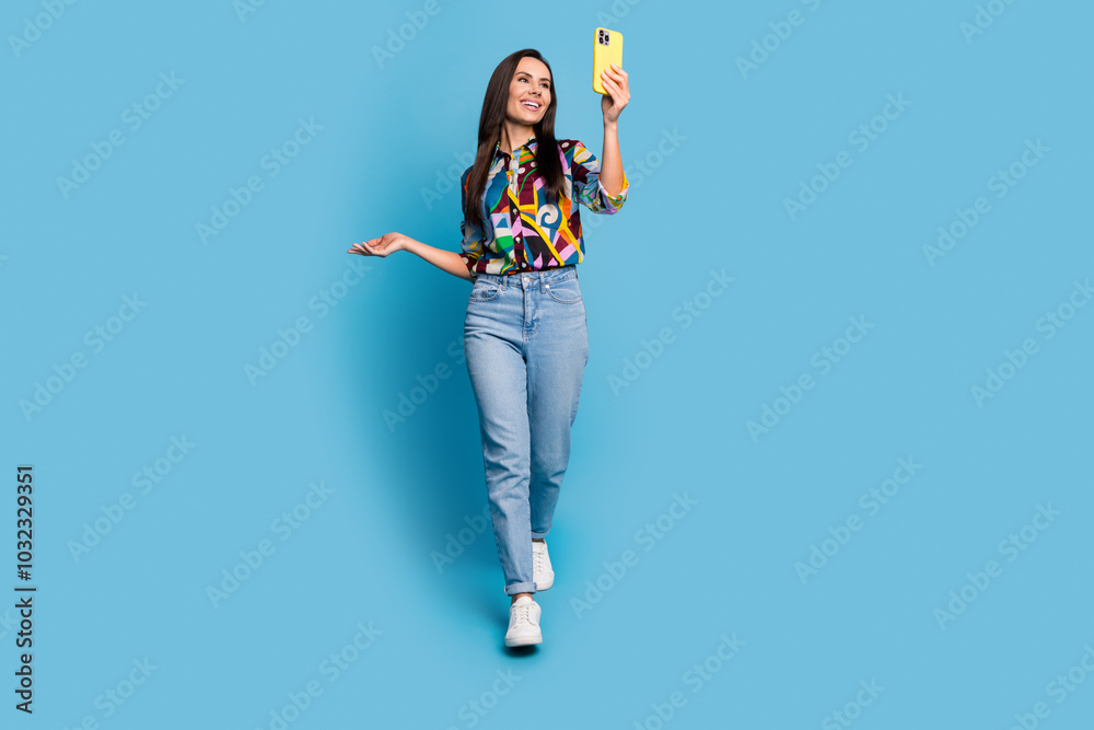 Φωτογραφία Full length photo of positive cheerful woman wear print shirt look at smartphone