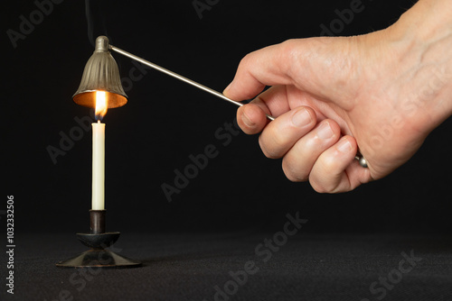 Extinguish a candle with candle snuffer photo