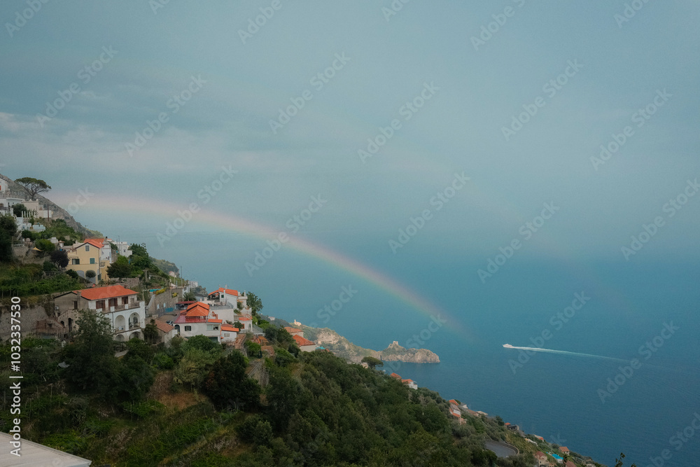 custom made wallpaper toronto digitalScenic view of the Amalfi Coast with a small boat on the horizon, rainbow arching over the sea, and cliffside homes. This picturesque coastal scene captures the beauty of Italy's Amalfi Coast 