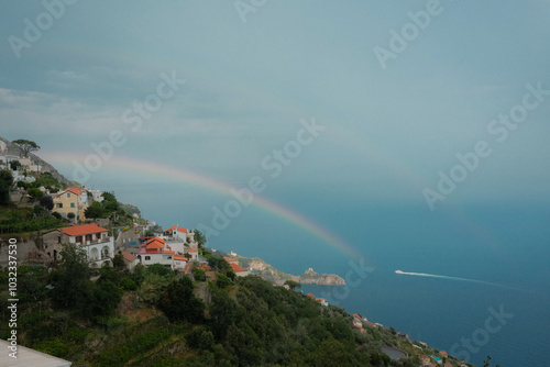 Wallpaper Mural Scenic view of the Amalfi Coast with a small boat on the horizon, rainbow arching over the sea, and cliffside homes. This picturesque coastal scene captures the beauty of Italy's Amalfi Coast  Torontodigital.ca