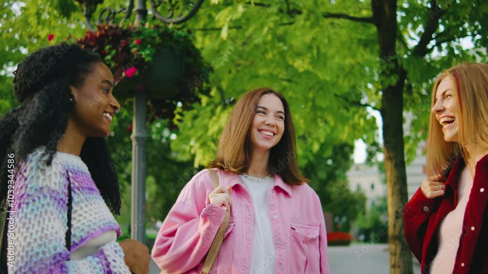 A joyful gathering of young women taking pleasure in friendly interaction within an urban park, showcasing lively moments filled with connection and shared laughter that bring happiness