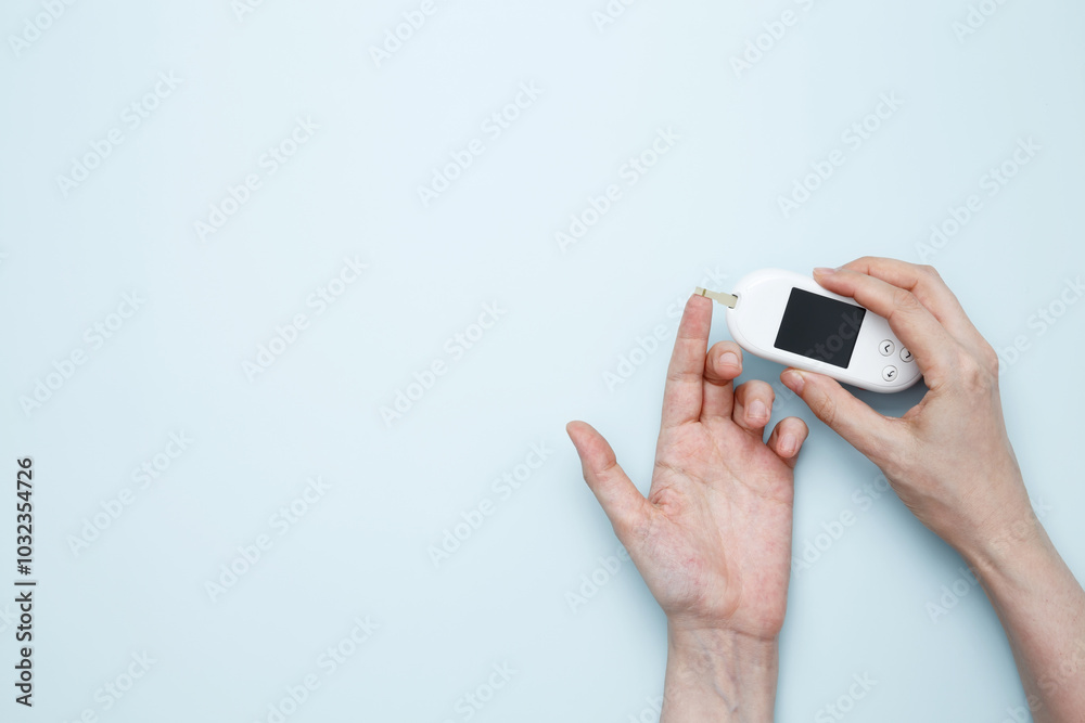 Woman hands holding glucometer for measuring blood glucose levels, lancet. Concept of worldwide diabetes awareness Woman hands holding glucometer for measuring blood glucose levels, lancet. Concept of worldwide diabetes awareness
