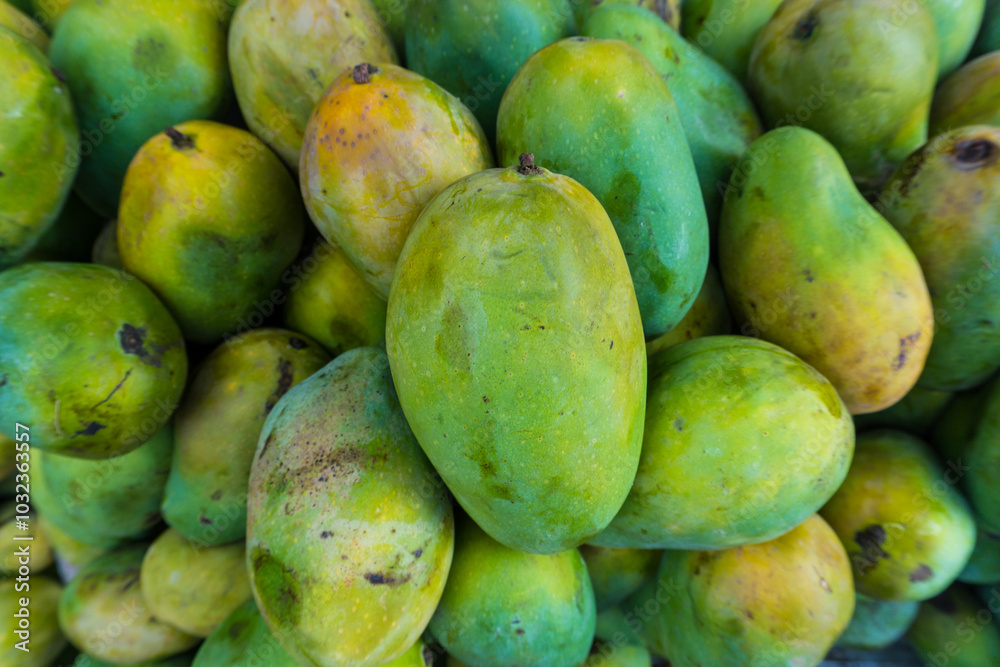 a pile of green mangoes in the traditional market. a pile of green mangoes in the traditional market.