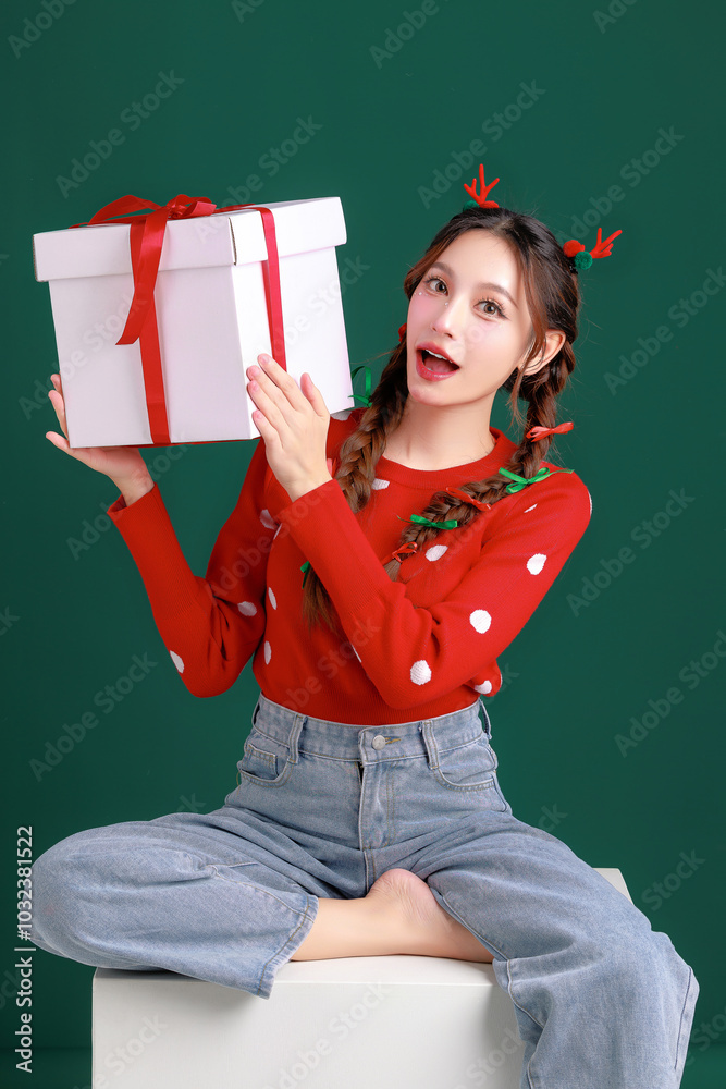 Young Beauty Asian happy woman wearing cozy red sweater dress and a reindeer antler hair clip holding gift boxes on green isolated background. winter, Happy new years concept.