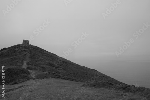 Rame Head Chapel located on a high cliff in the Mount Edgcumbe Country Park Cornwall England on a misty summer day photo