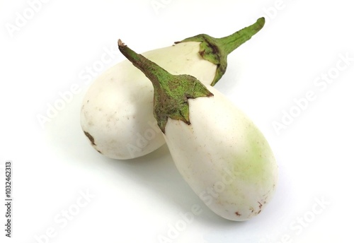 Top view of two fresh white eggplants, isolated on white background. White eggplants are traditionally less bitter and acidic than purple eggplants, allowing them to be used in more versatile recipes. photo