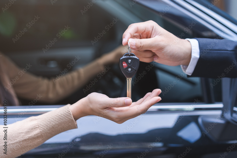 Fototapeta premium Business car rental, sell or buy service, dealership agent dealer sale hand giving auto key of vehicle to customer renter, buyer smile asian young woman receiving, client or tenant transfer automobile