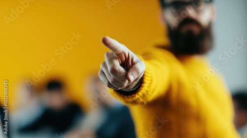 A person in a yellow sweater extends a hand pointing forward amidst a blur of other figures, embodying direction, leadership, and assertiveness in a group setting.