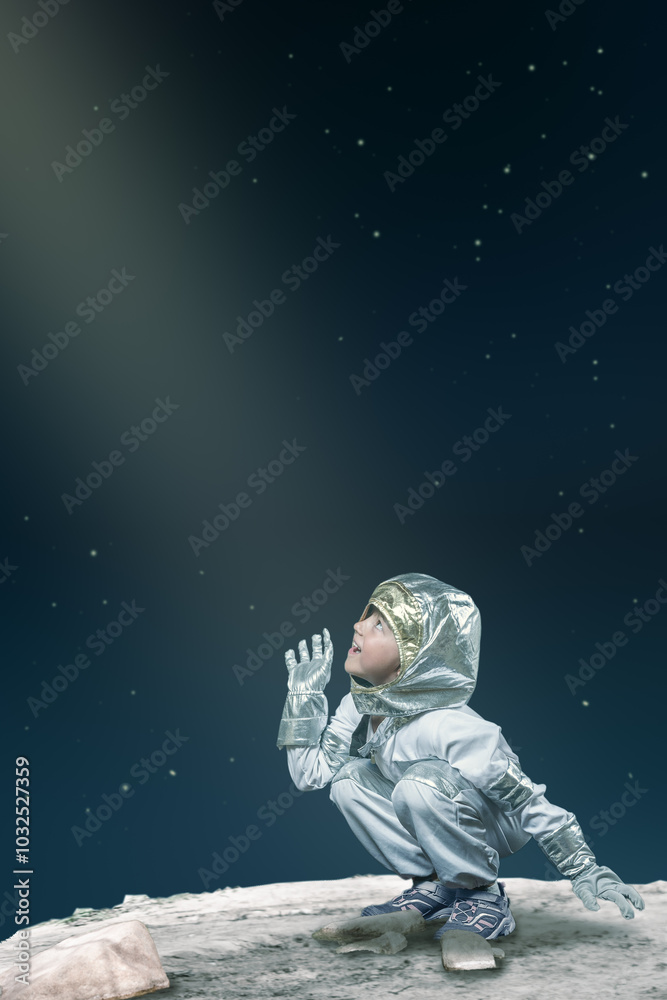 A young boy in a spacesuit is looking up at the stars A young boy in a spacesuit is looking up at the stars