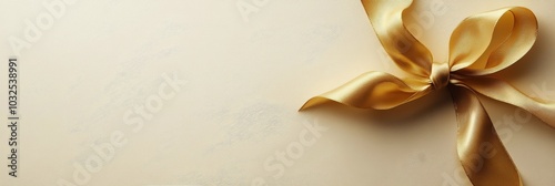 Elegant golden ribbon tied on a soft beige background for gift wrapping or de...