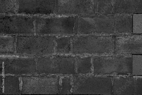 The black wall is made of stone and it is very thick.