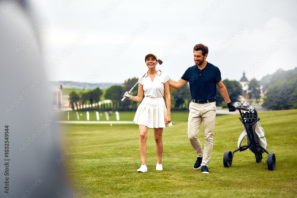 Obraz premium A Happy Couple Enjoying a Wonderful Day on the Golf Course with Their Golf Cart and Equipment