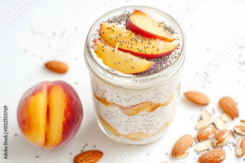 Peach and almond chia yogurt parfait in a glass jar on white background. photo