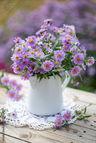 Bel mazzo di fiori autunnali aster o settembrini di colore lilla su un vaso bianco di latta