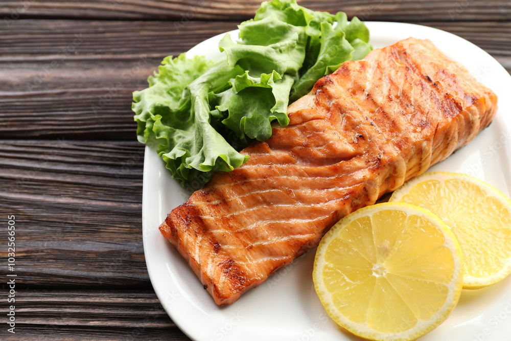 Delicious grilled salmon fillet served on wooden table, closeup Delicious grilled salmon fillet served on wooden table, closeup