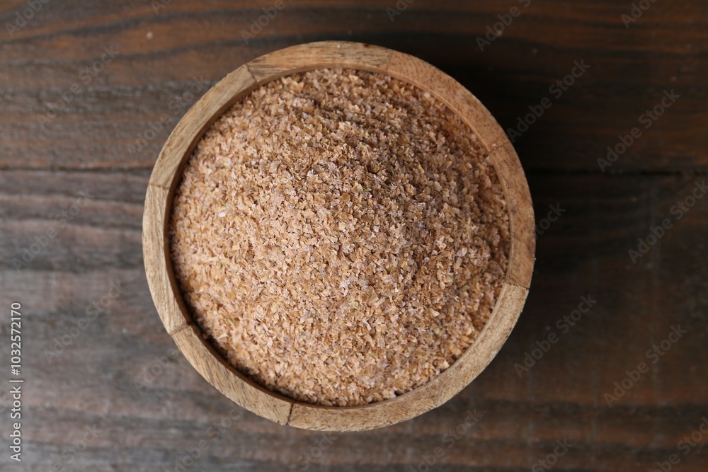 Buckwheat bran in bowl on wooden table, top view Buckwheat bran in bowl on wooden table, top view