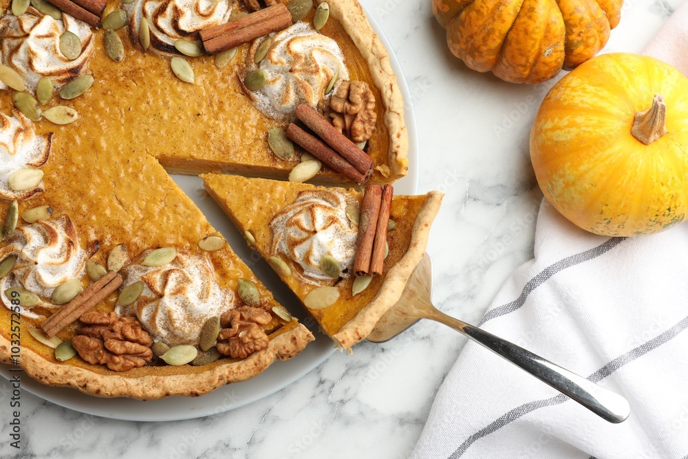 Fototapeta premium Tasty homemade pumpkin pie with ingredients and server on white marble table, flat lay