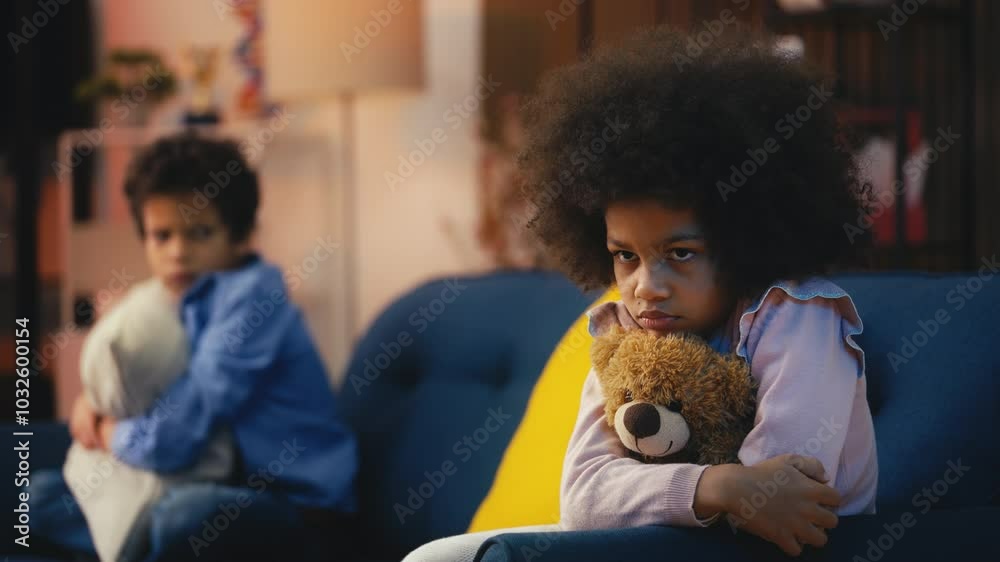 Sad African American girl and her brother sitting apart on sofa, kids fight Sad African American girl and her brother sitting apart on sofa, kids fight