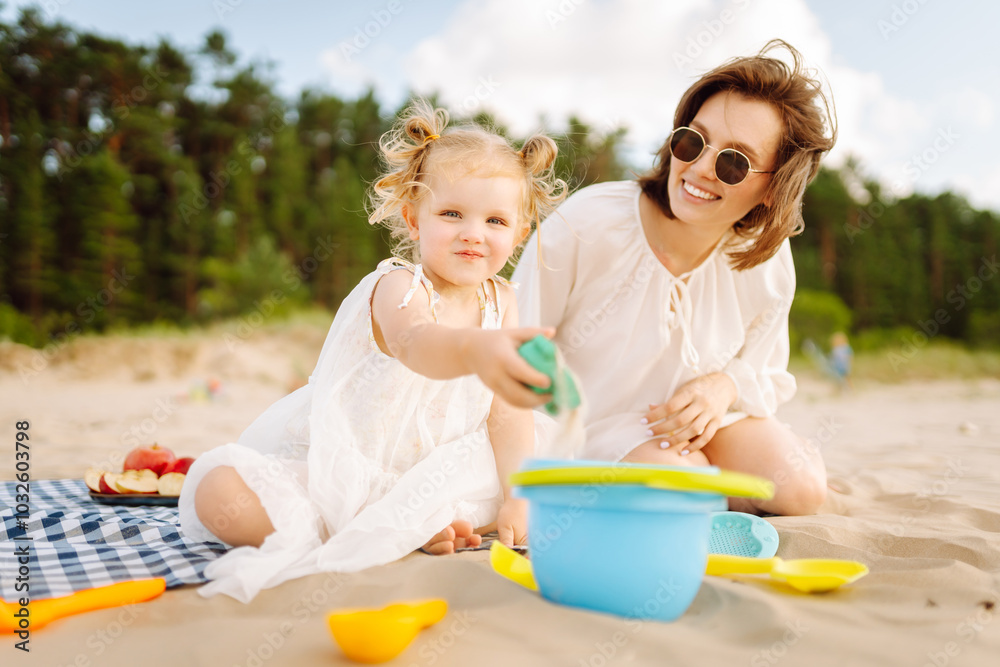Mother and daughter enjoying time at the beach. Plays toys. Family vacation. Mother and daughter enjoying time at the beach. Plays toys. Family vacation.
