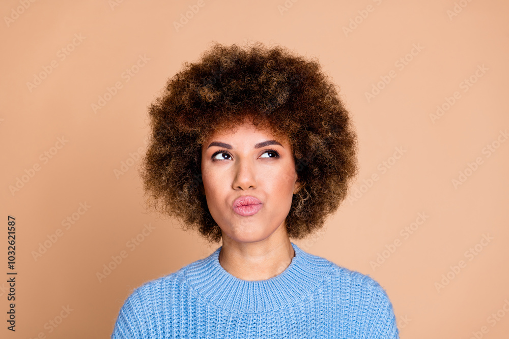 Photo of young funky american lady with brown hair chevelure in blue knitted sweater looking guessing isolated on beige color background Photo of young funky american lady with brown hair chevelure in blue knitted sweater looking guessing isolated on beige color background