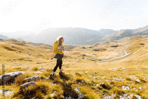 Young woman backpacker on mountains cliff hiking enjoy landscape. Adventure active. Mountain climbing.