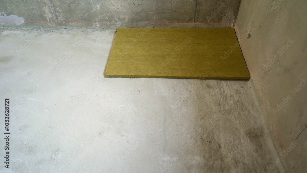 Construction worker laying down acoustic insulation panel Construction worker laying down acoustic insulation panel