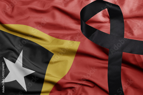 waving national flag of east timor with black mourning ribbon .tragedy concept