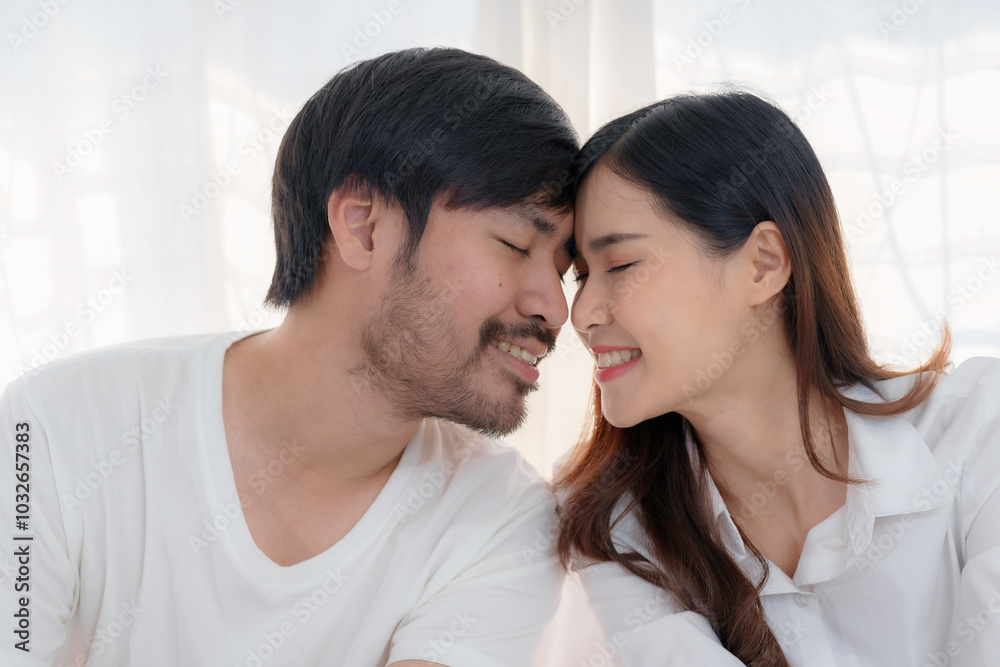 Young couple is enjoying each other's company at home, their foreheads touching and their eyes closed in a moment of love and connection Young couple is enjoying each other's company at home, their foreheads touching and their eyes closed in a moment of love and connection