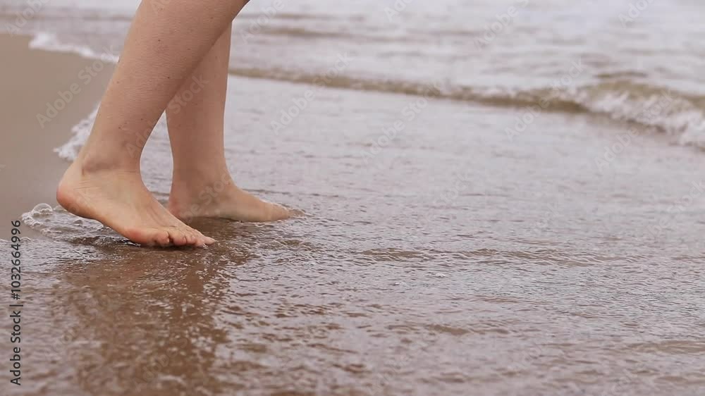 Female legs on the beach, sea, close-up. Bare feet against the background of sea waves. Female legs close-up, beach vacation. Relaxing on the beach, summer vacation Female legs on the beach, sea, close-up. Bare feet against the background of sea waves. Female legs close-up, beach vacation. Relaxing on the beach, summer vacation
