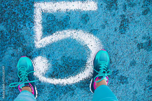 athlete runner woman ready in the lane of the blue running track photo