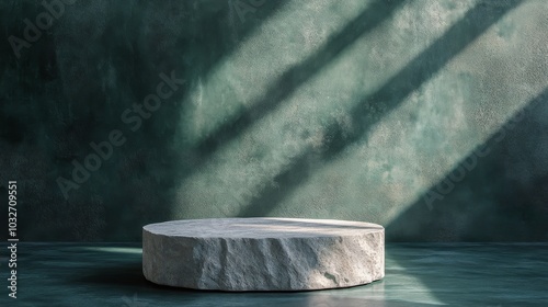 Minimalistic round stone pedestal in a dimly lit space with textured green wa...