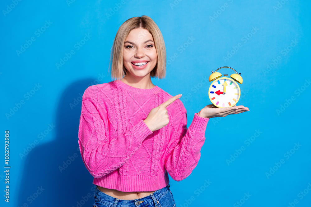 Photo of pretty young woman point finger alarm wear pink pullover isolated on blue color background Photo of pretty young woman point finger alarm wear pink pullover isolated on blue color background