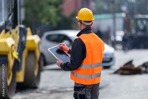 Foto Construction worker in a safety vest using a tablet on a busy street during the