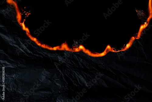 burning paper, glowing edge of paper on a black background