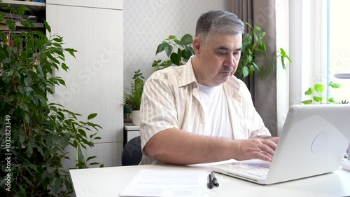 Close-up shot of a male freelancer working from home on a computer. Suitable for content related to freelancing and remote work.
