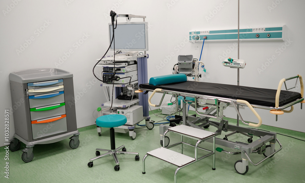 A clean, modern medical room equipped with an examination table, medical instruments, a monitor, and various medical devices, ready for patient procedures in a professional healthcare setting. A clean, modern medical room equipped with an examination table, medical instruments, a monitor, and various medical devices, ready for patient procedures in a professional healthcare setting.