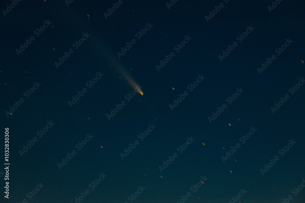 Comet Tsuchinshan-ATLAS shines brightly as it streaks across the night sky with a long glowing tail. The comet is surrounded by numerous faint stars, creating a captivating celestial scene against the Comet Tsuchinshan-ATLAS shines brightly as it streaks across the night sky with a long glowing tail. The comet is surrounded by numerous faint stars, creating a captivating celestial scene against the