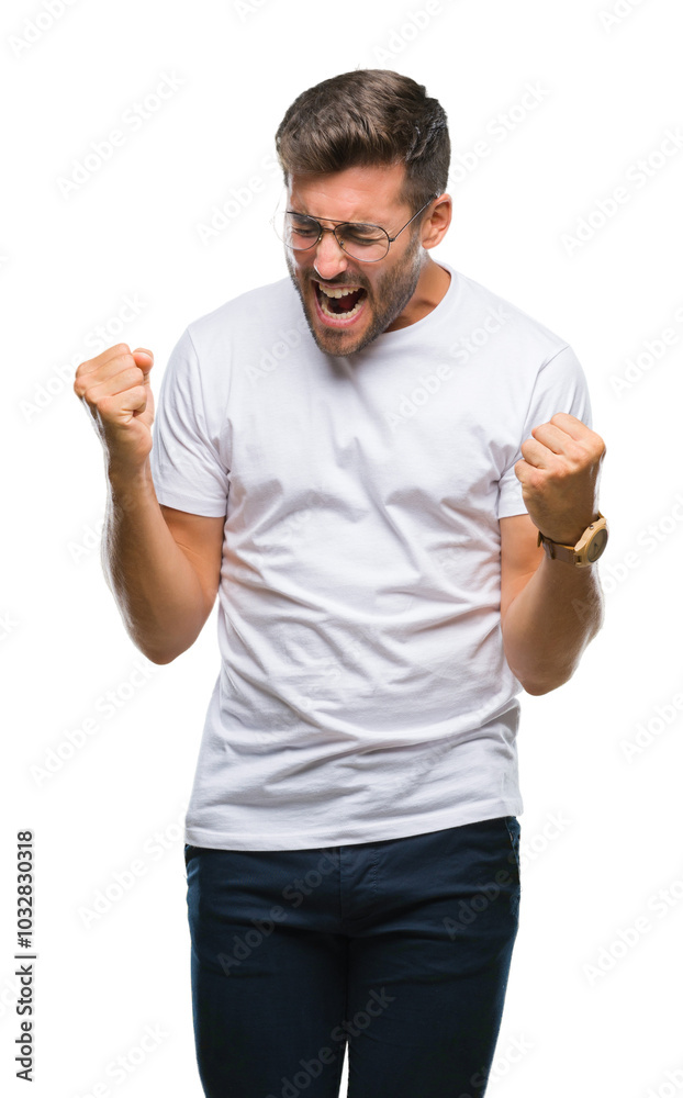 Young handsome man wearing glasses over isolated background very happy and excited doing winner gesture with arms raised, smiling and screaming for success. Celebration concept. Young handsome man wearing glasses over isolated background very happy and excited doing winner gesture with arms raised, smiling and screaming for success. Celebration concept.