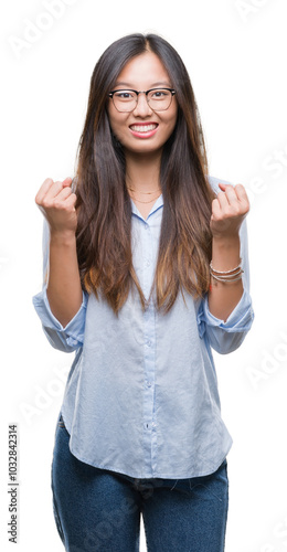 Young asian business woman wearing glasses over isolated background celebrating surprised and amazed for success with arms raised and open eyes. Winner concept.