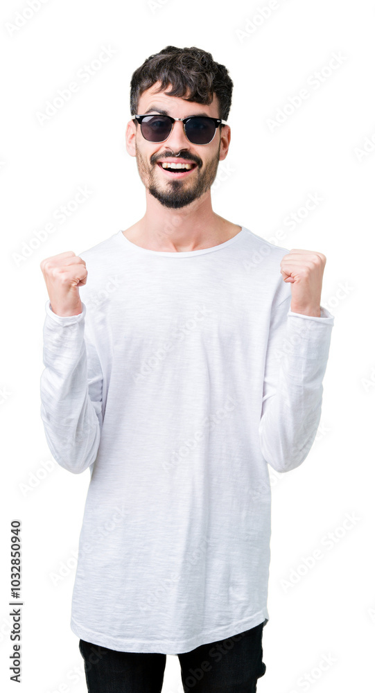 Young handsome man wearing sunglasses over isolated background celebrating surprised and amazed for success with arms raised and open eyes. Winner concept. Young handsome man wearing sunglasses over isolated background celebrating surprised and amazed for success with arms raised and open eyes. Winner concept.