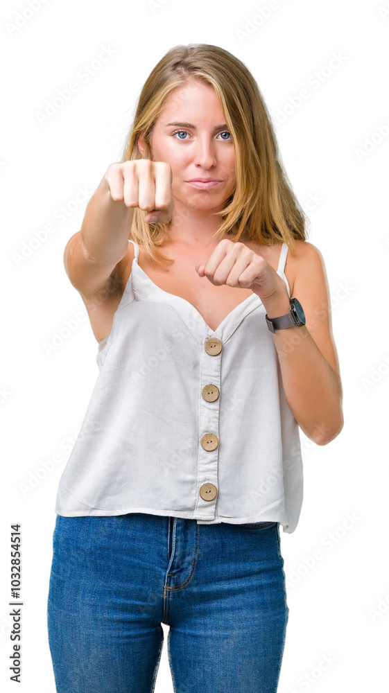Beautiful young woman over isolated background Punching fist to fight, aggressive and angry attack, threat and violence Beautiful young woman over isolated background Punching fist to fight, aggressive and angry attack, threat and violence