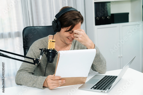 Host channel in smart broadcaster with talking show on live social media streaming with script note reading to listeners, wearing headphones to record video streamer at modern home studio. Pecuniary.