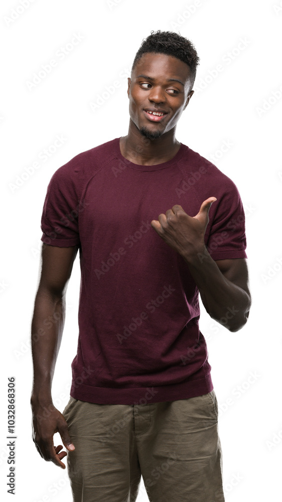 Young african american man pointing with hand and finger up with happy face smiling