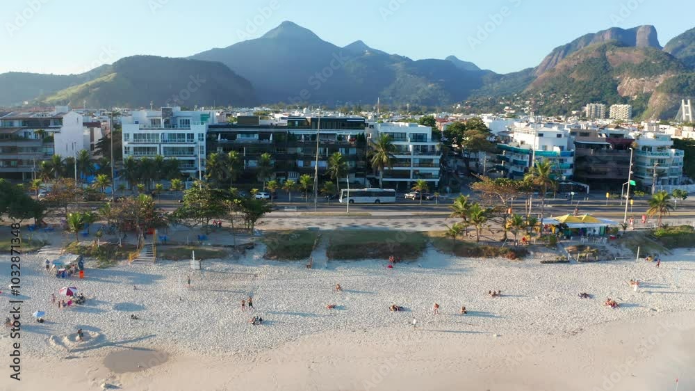 Aerial view of Barra da Tijuca Beach in Rio de Janeiro, with buildings and mountains in the background. Aerial view of Barra da Tijuca Beach in Rio de Janeiro, with buildings and mountains in the background.