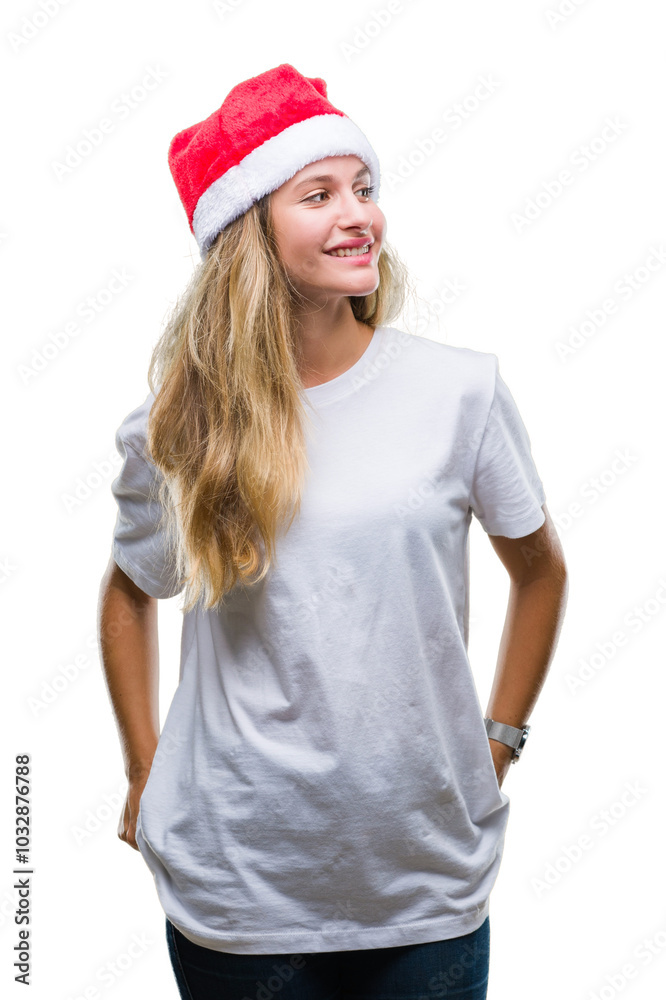 Young beautiful blonde woman wearing christmas hat over isolated background looking away to side with smile on face, natural expression. Laughing confident. Young beautiful blonde woman wearing christmas hat over isolated background looking away to side with smile on face, natural expression. Laughing confident.